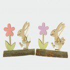 Wooden rabbit with egg and flower on a wooden trunk