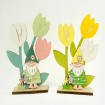 Funny garden gnome on a wooden trunk with lots of flowers