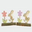 Wooden rabbit with egg and flower on a wooden trunk